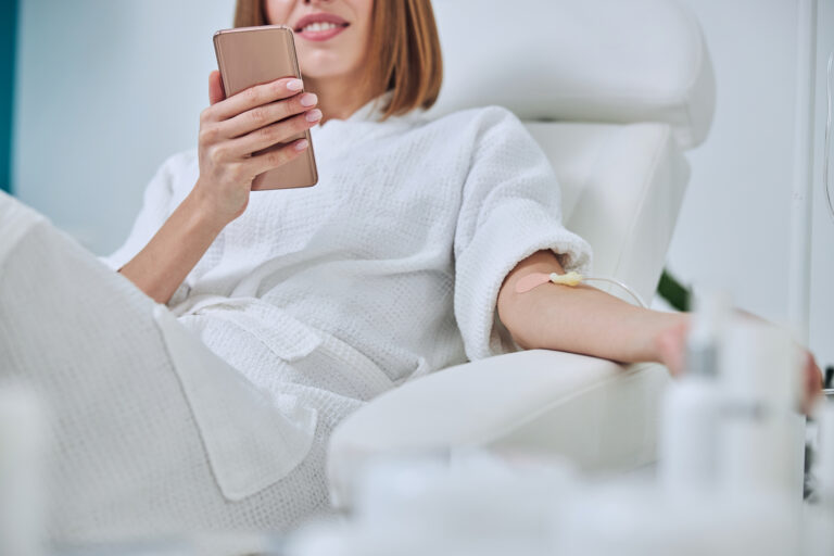 beautiful caucasian woman sitting in armchair during medicine procedure in spa salon